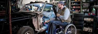 inspirational|XLT Max BE01.jpg|Manual wheelchair XLT Max blue frame man working on a car